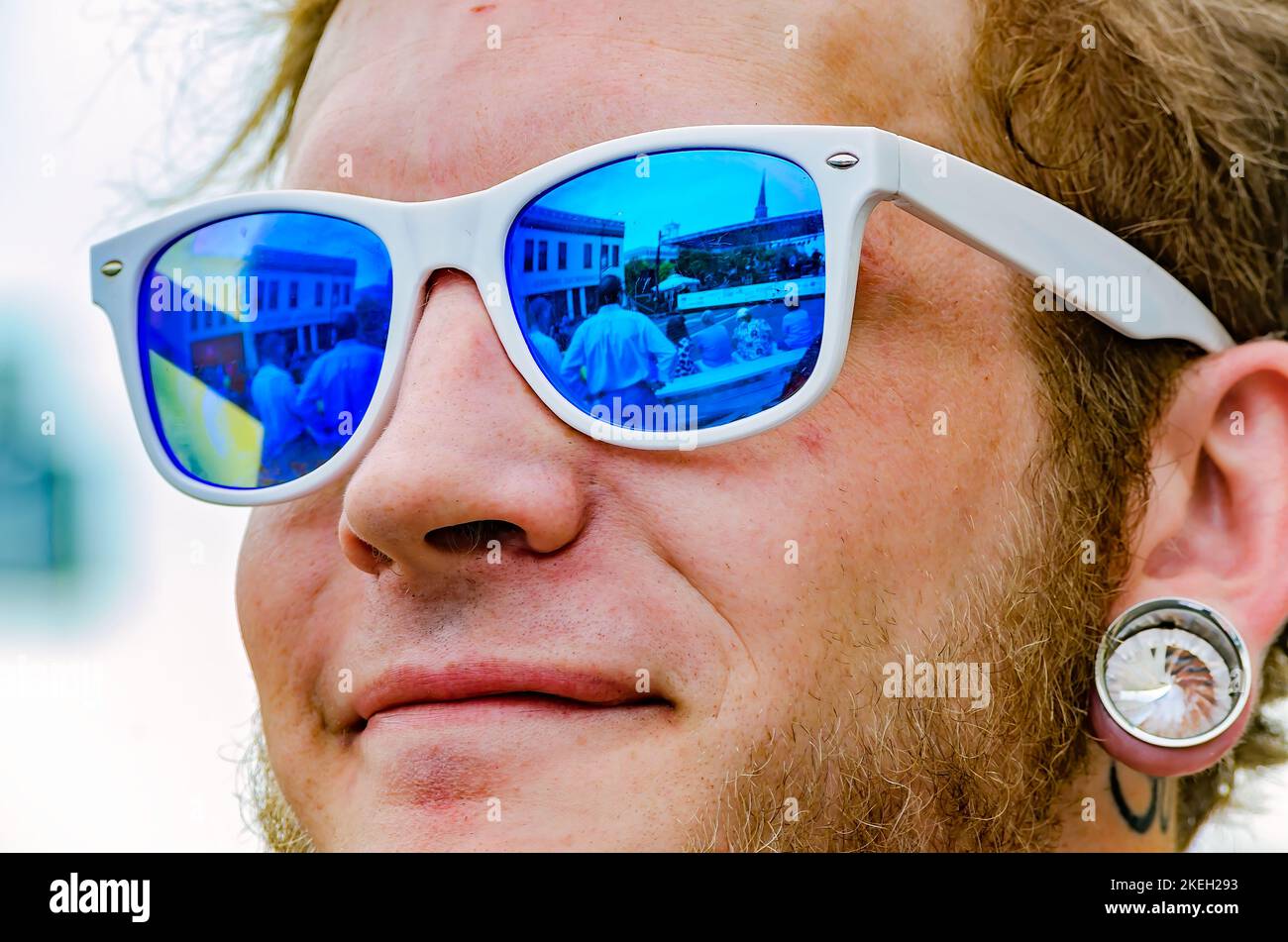 A man wears sunglasses and a plug earring during the Market Street Festival, May 5, 2012, in Columbus, Mississippi. Stock Photo