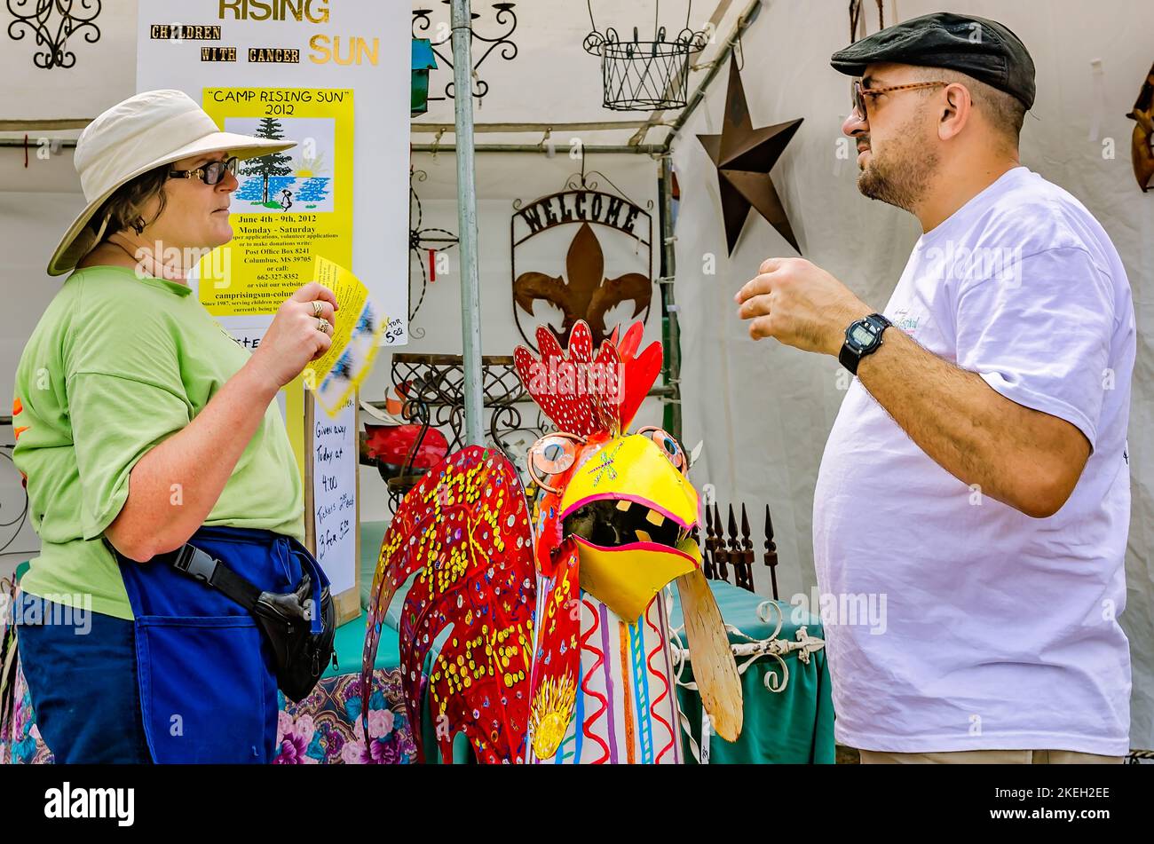 A woman discusses metal art with a street vendor during the Market Street Festival, May 5, 2012, in Columbus, Mississippi. Stock Photo