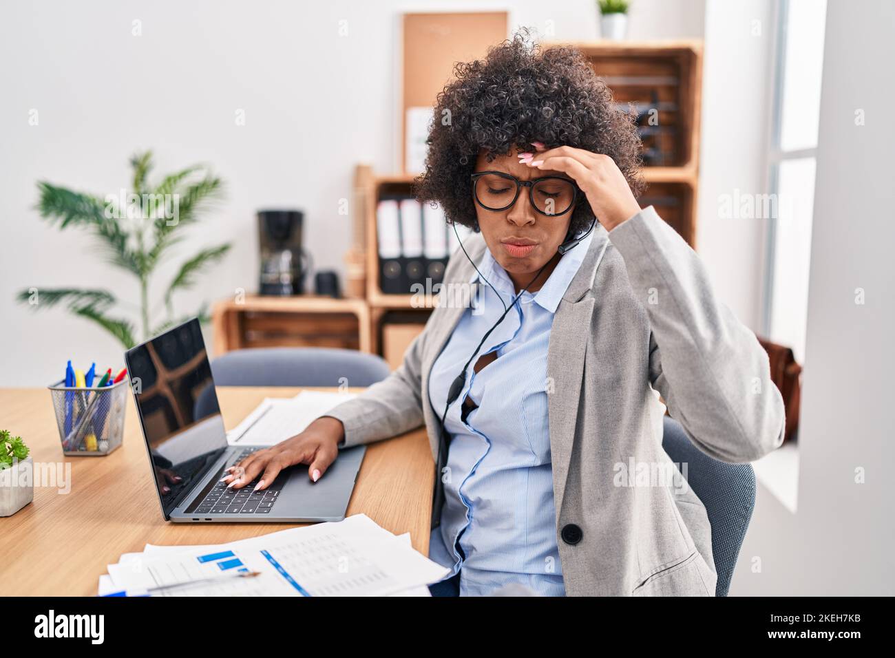 Black woman with curly hair wearing call center agent headset at the ...