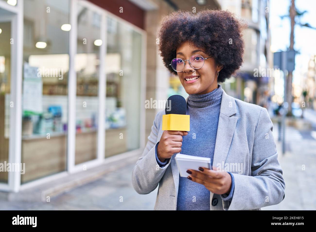 African american woman reporter working using microphone and notebook ...