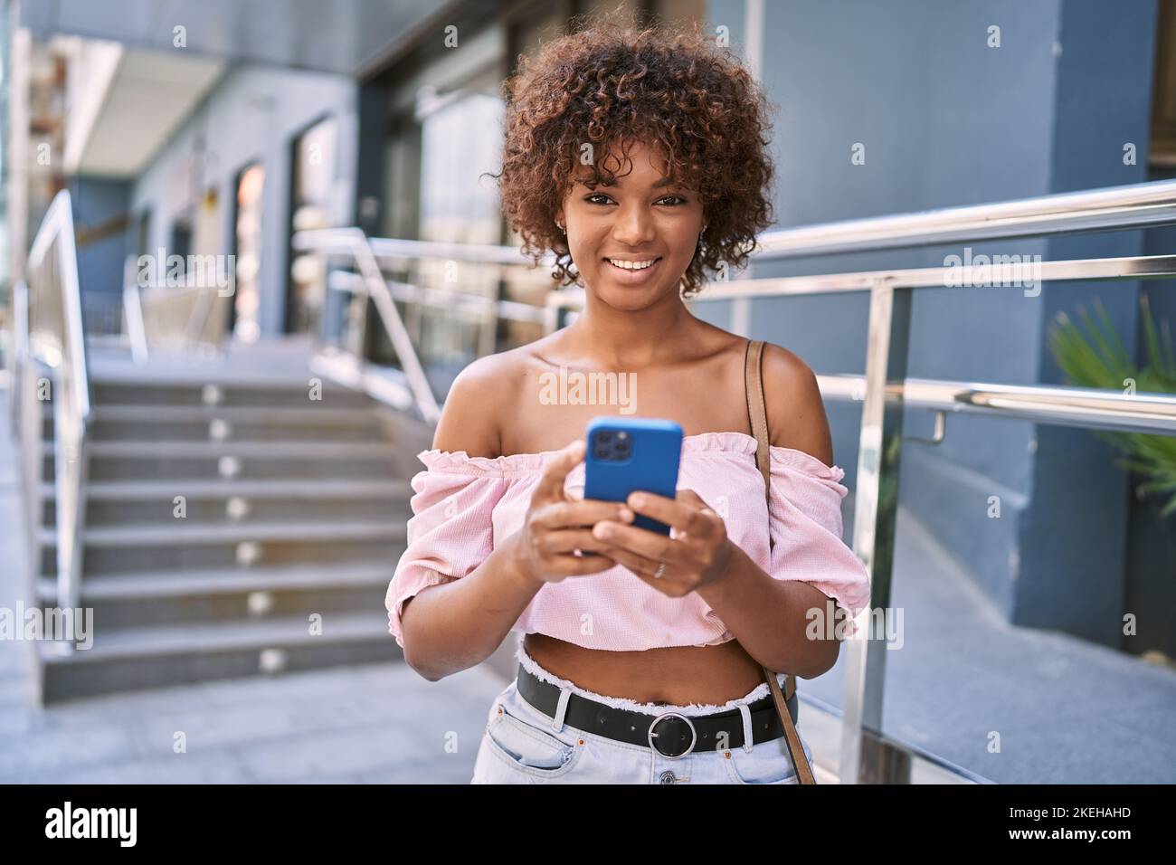 Young african american girl smiling happy using smartphone at the city ...