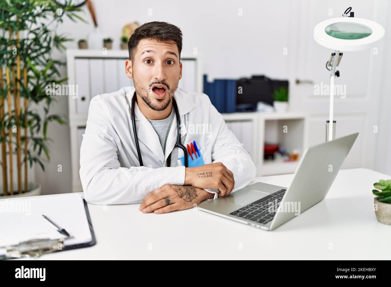 Young doctor working at the clinic using computer laptop afraid and ...