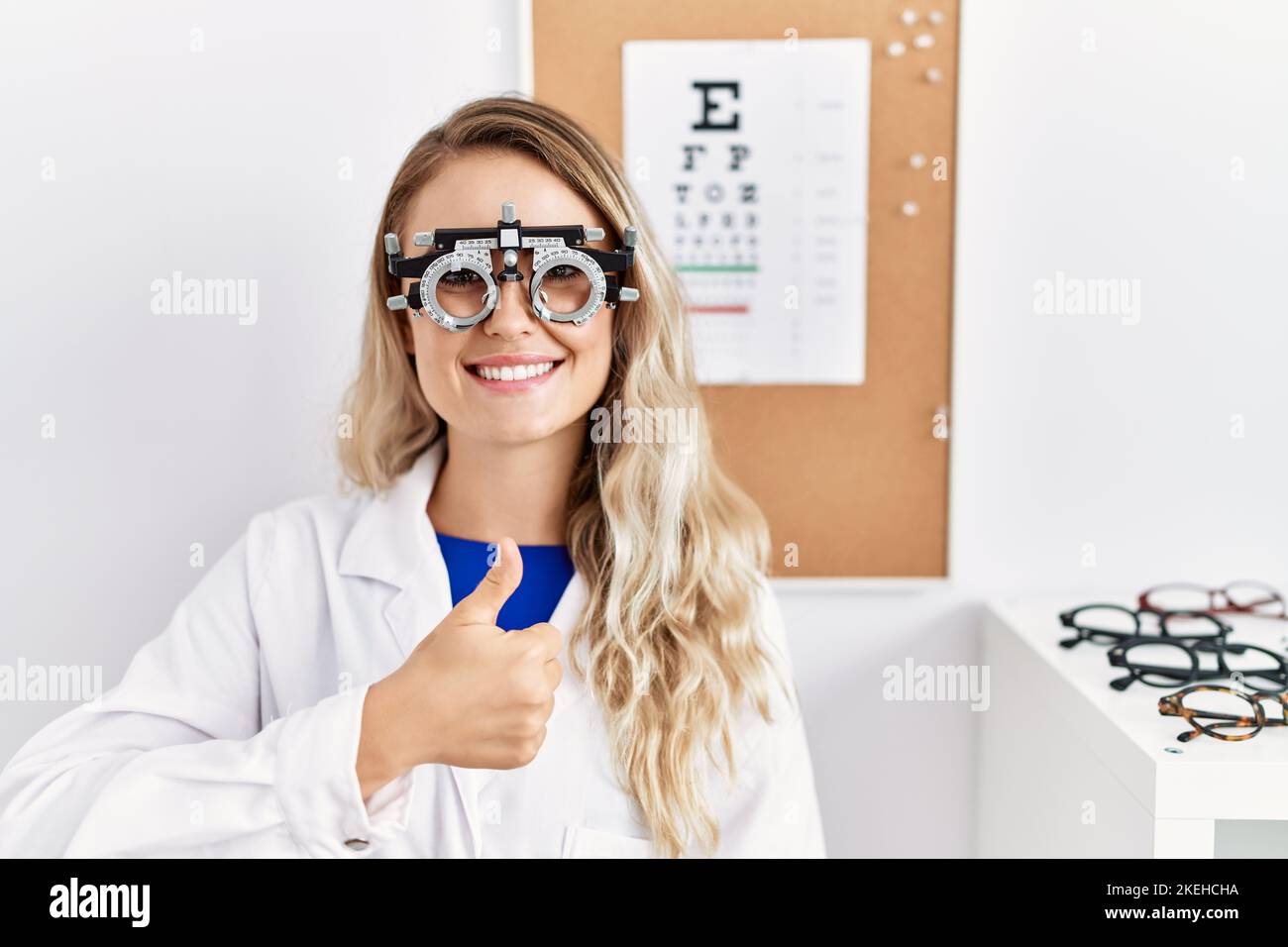 Young beautiful optician woman wearing optometry glasses at the clinic ...