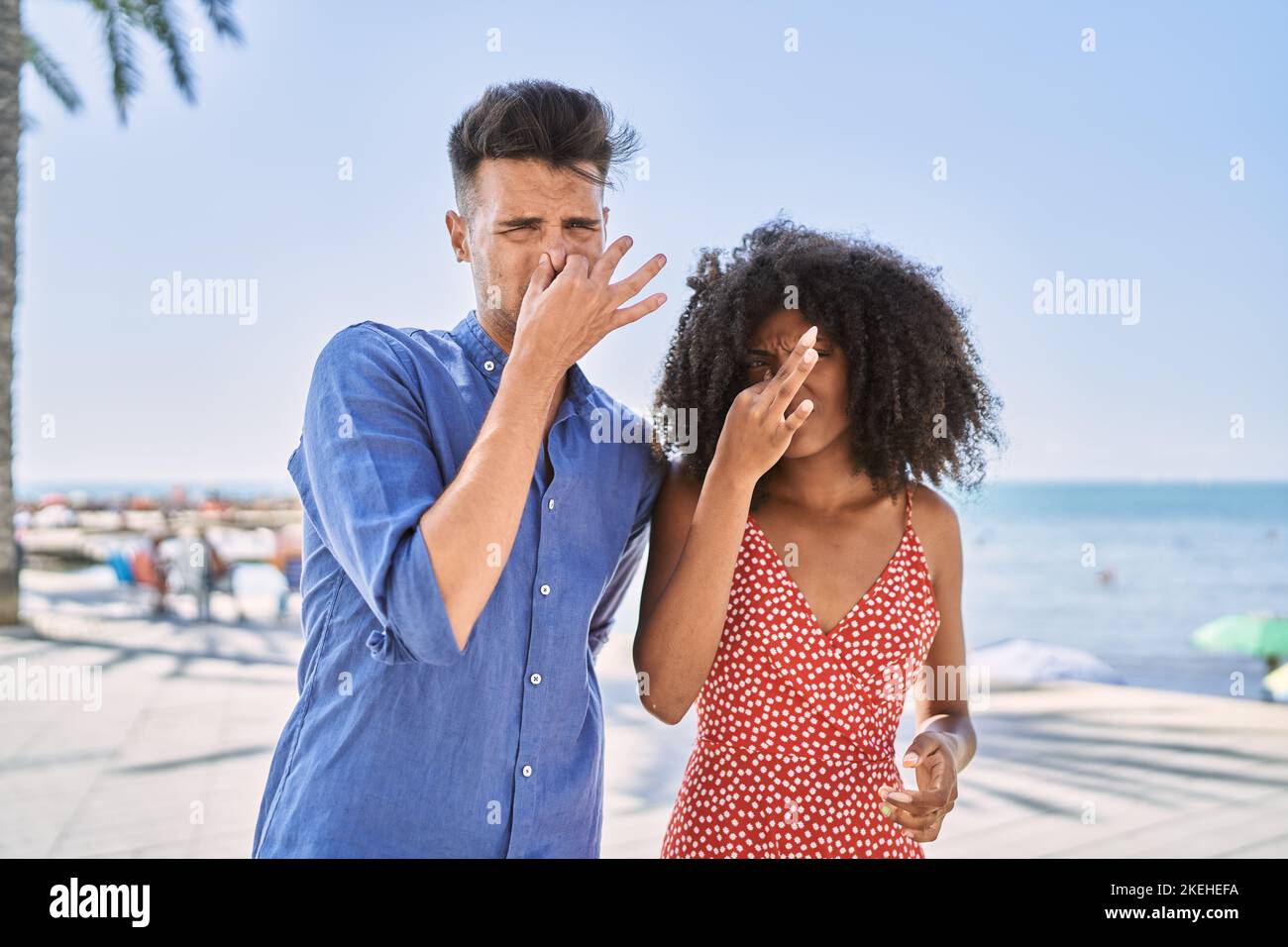Intolerable Couples Young interracial couple outdoors on a sunny day smelling something ...