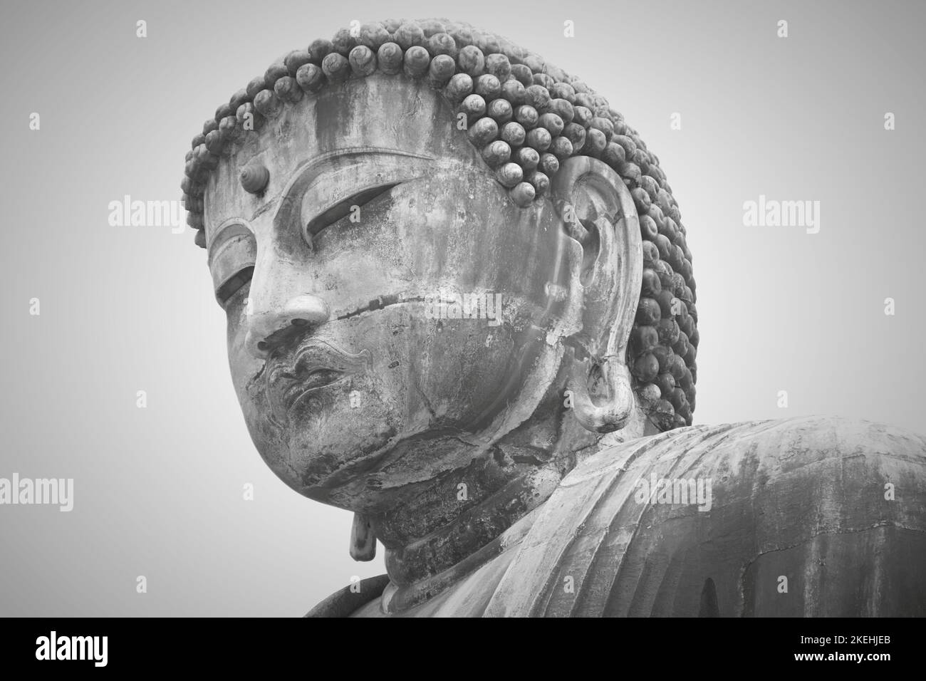 Peaceful eyes wide shut view of Great Buddha (Daibutsu) large bronze statue representing Amida Buddha (Amitabha) in Kamakura Kotoku-in Buddhist temple Stock Photo