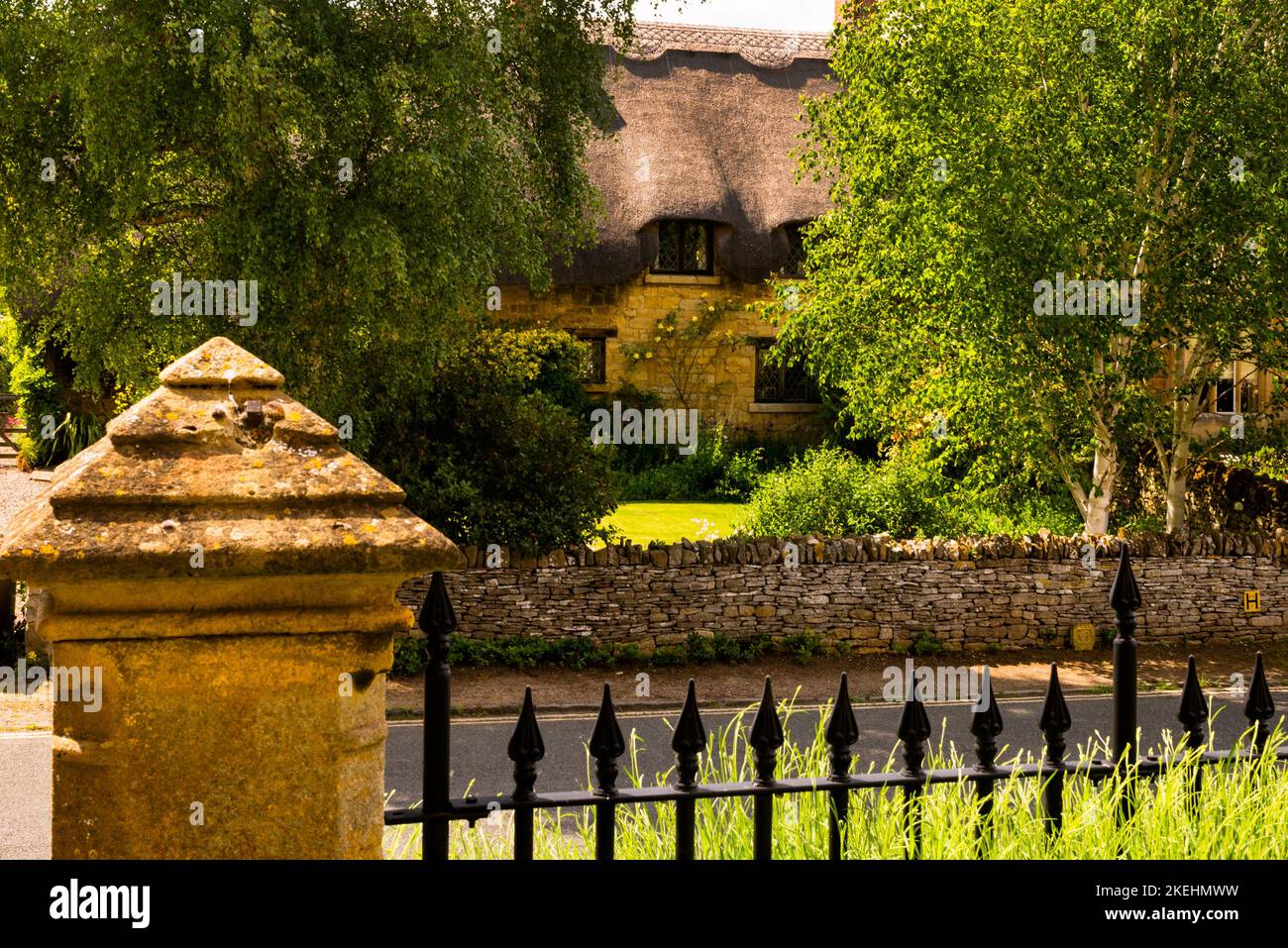 Beautiful Cotswolds estate house with thatched roof and dormers in the