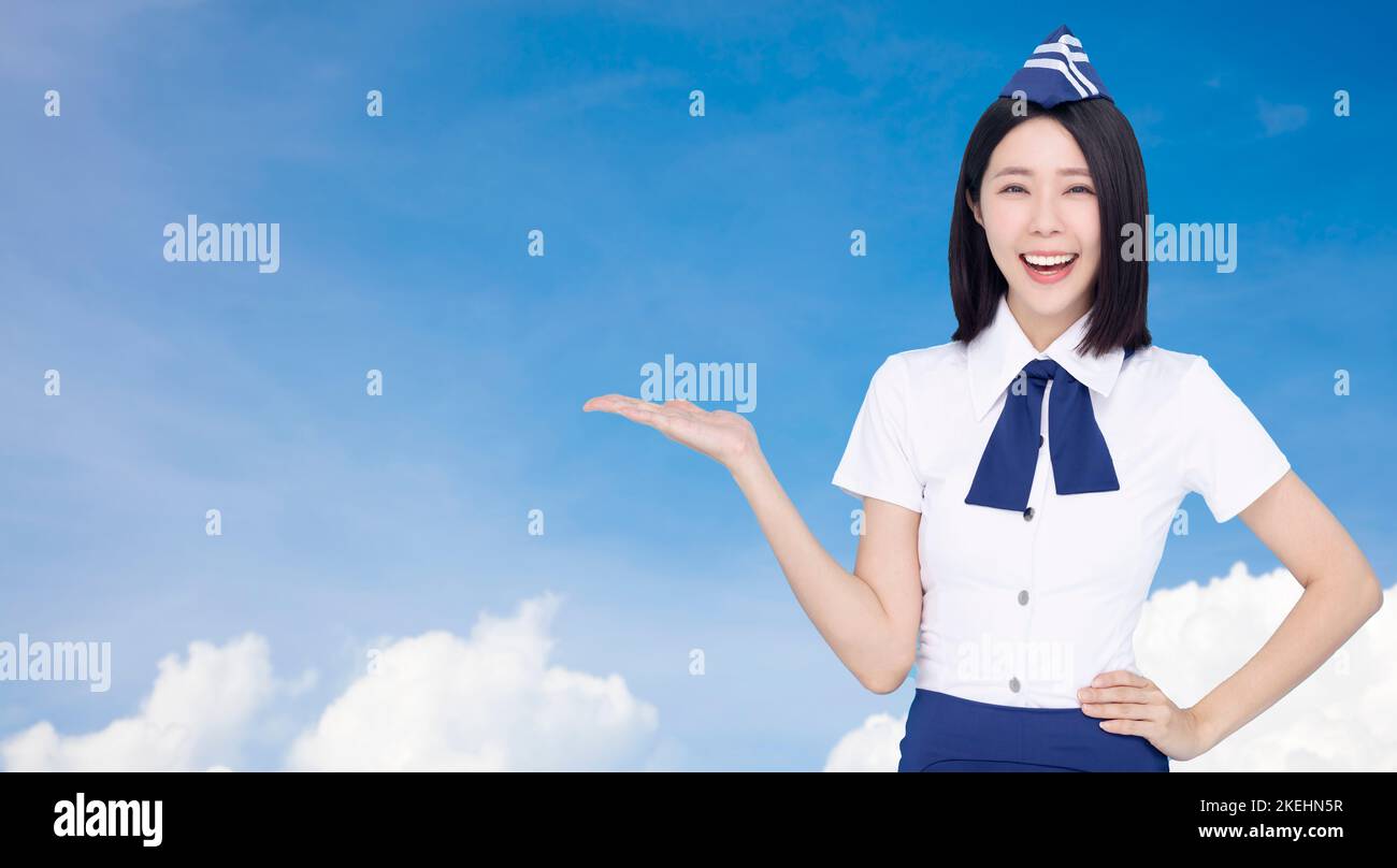 Happy Beautiful stewardess showing something on cloud background Stock Photo