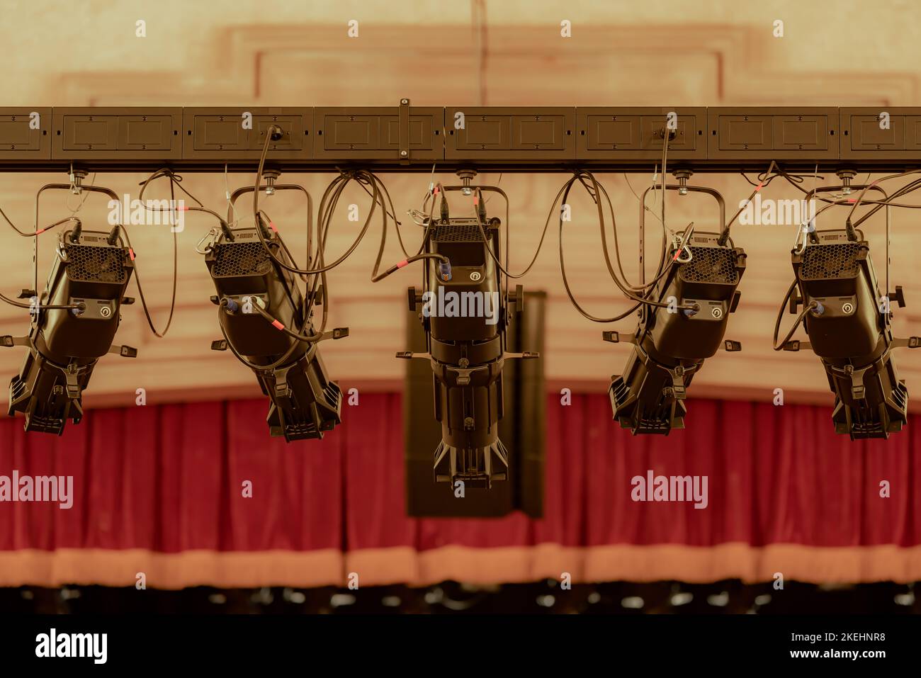 Closeup photo of five new large theater spot lights hung within an older theatre or auditorium. Stock Photo