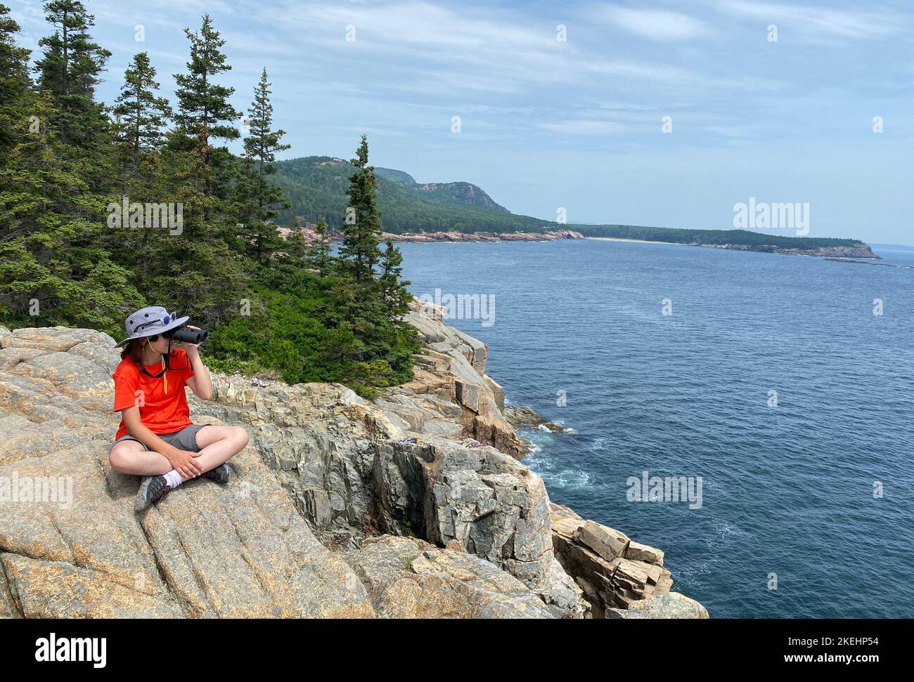 Young girl teenager admiring the coastline of Atlantic Ocean in Acadia National Park, Maine Stock Photo