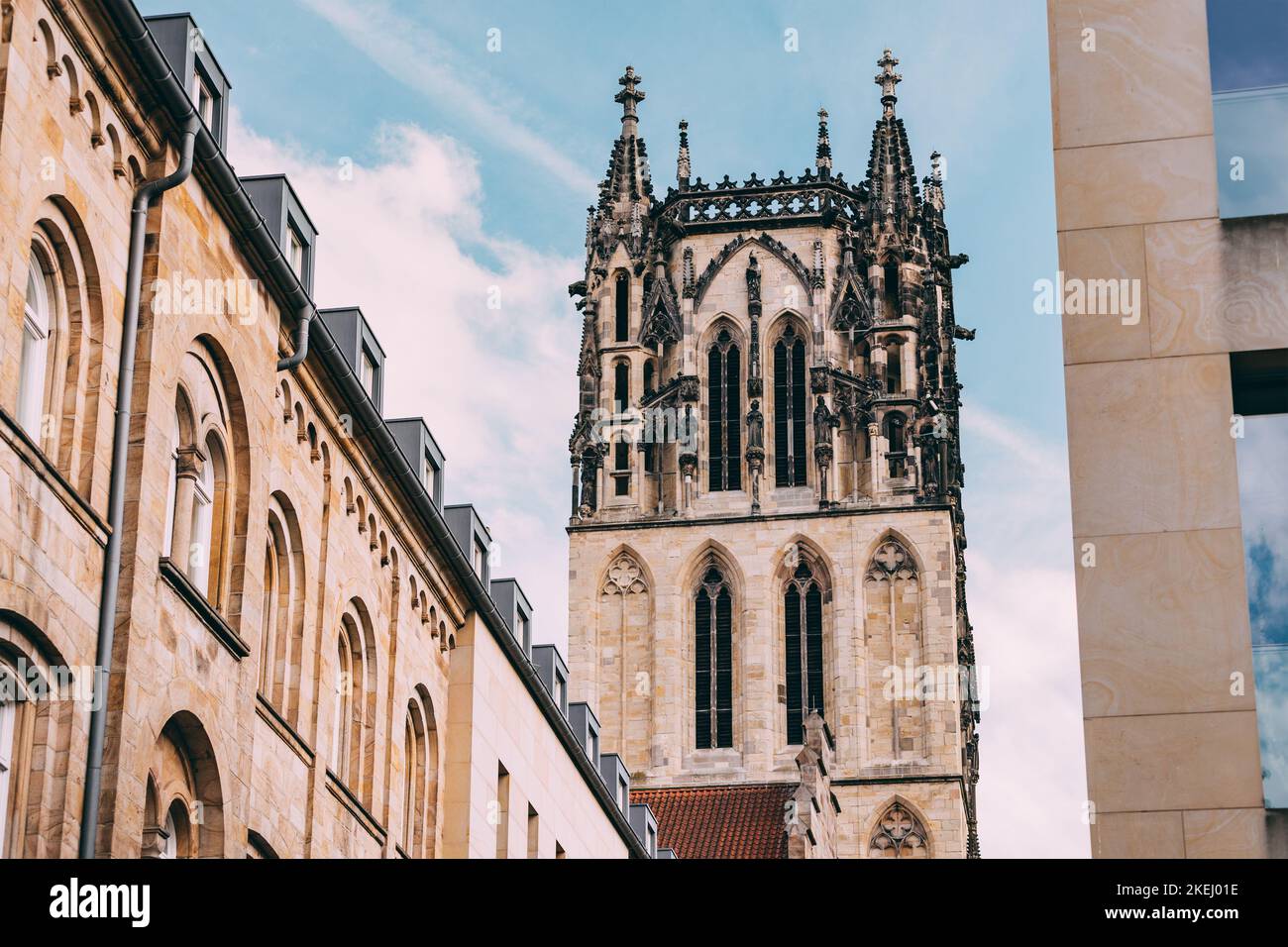 Old town street with Liebfrauen or Uberwasserkirche church tower in Munster, Germany. City life and travel concept Stock Photo