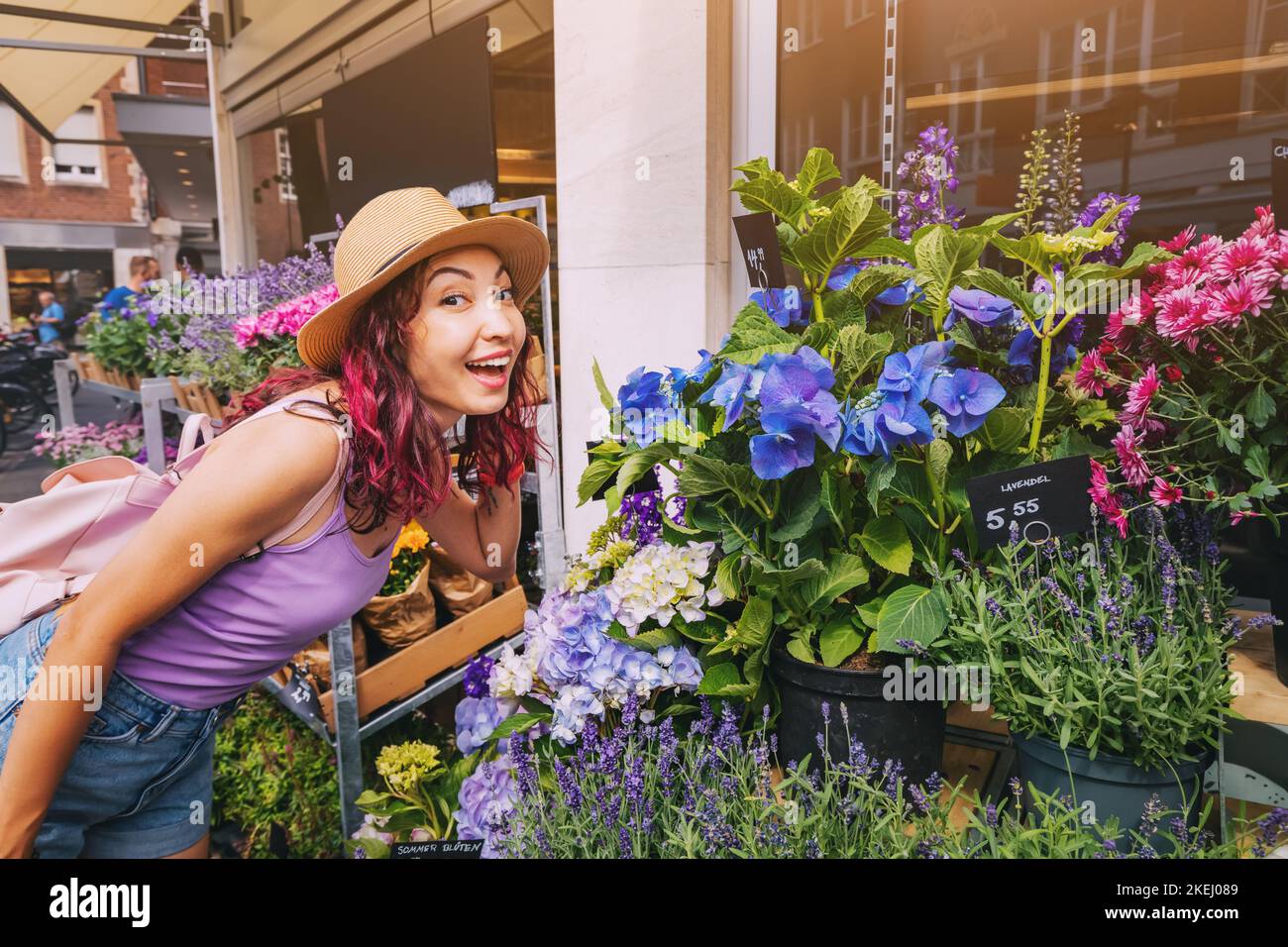 Happy girl buyer and a client choose bouquets and flowers in pots for markets and florist shop on a city street Stock Photo
