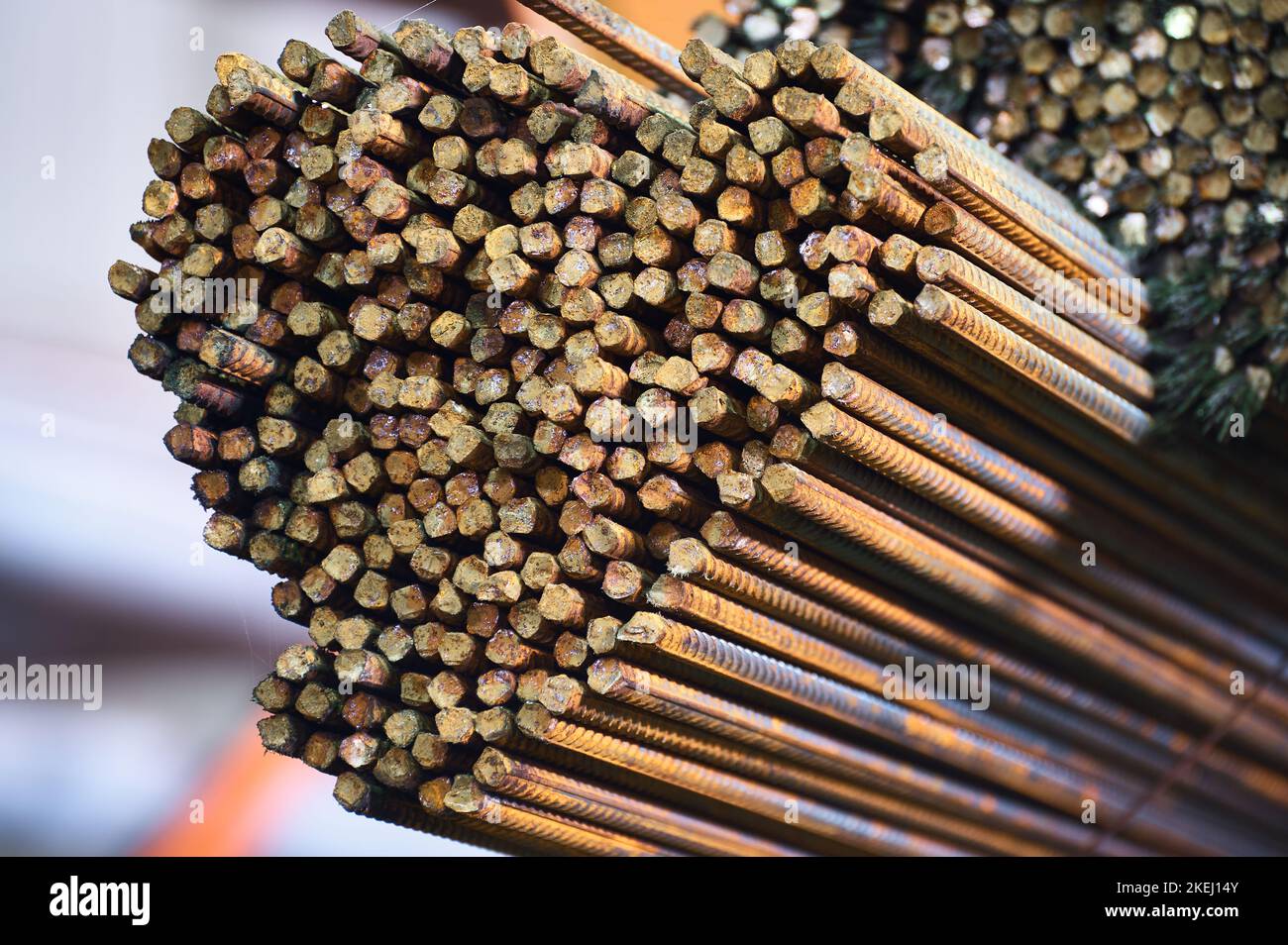 Thin metal rods stack on large rack in cold plant warehouse Stock Photo