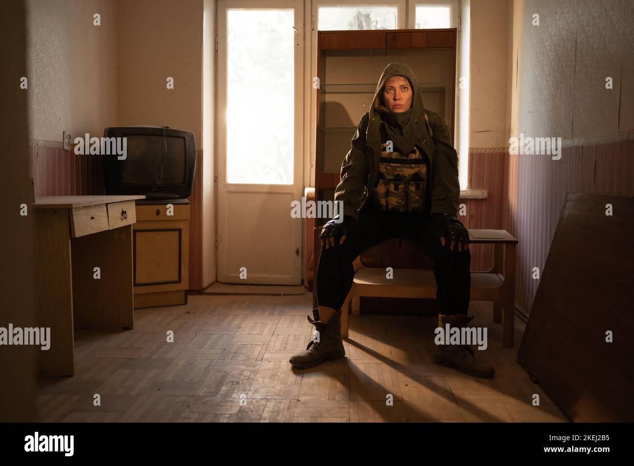 Environmental disaster. Post apocalyptic female survivor in abandoned building. A lonely hero wearing military wearing Stock Photo