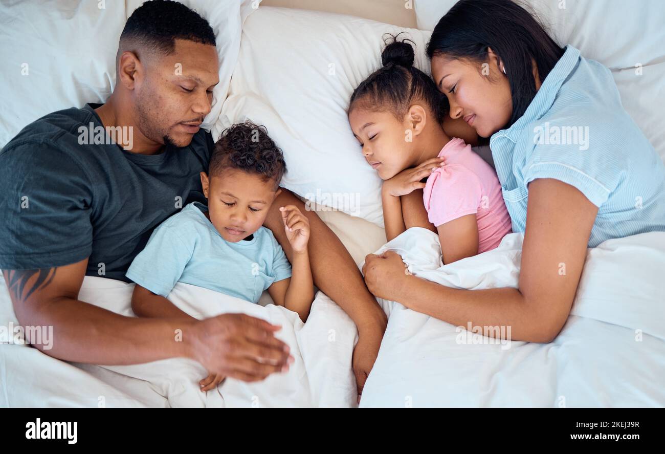 Family, sleeping and in bed together, love and care with parents and children at family home