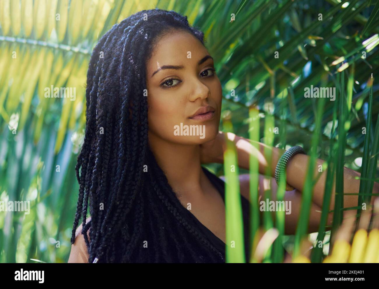 Shes an exotic mystery. Portrait of an attractive young woman posing against a leafy background. Stock Photo