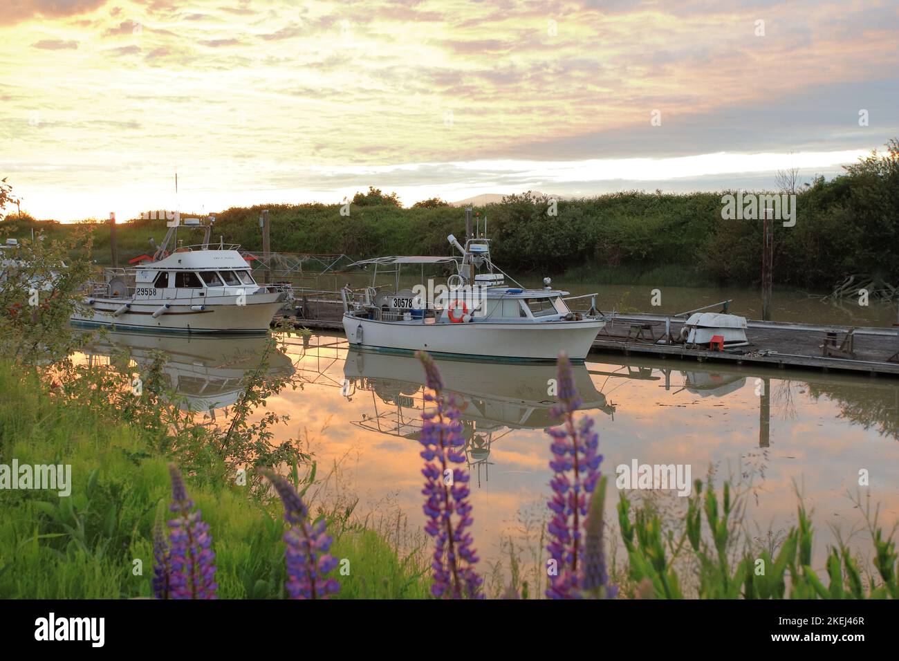 Fishing boat in a river dock under a sunset orange clouds Stock Photo ...