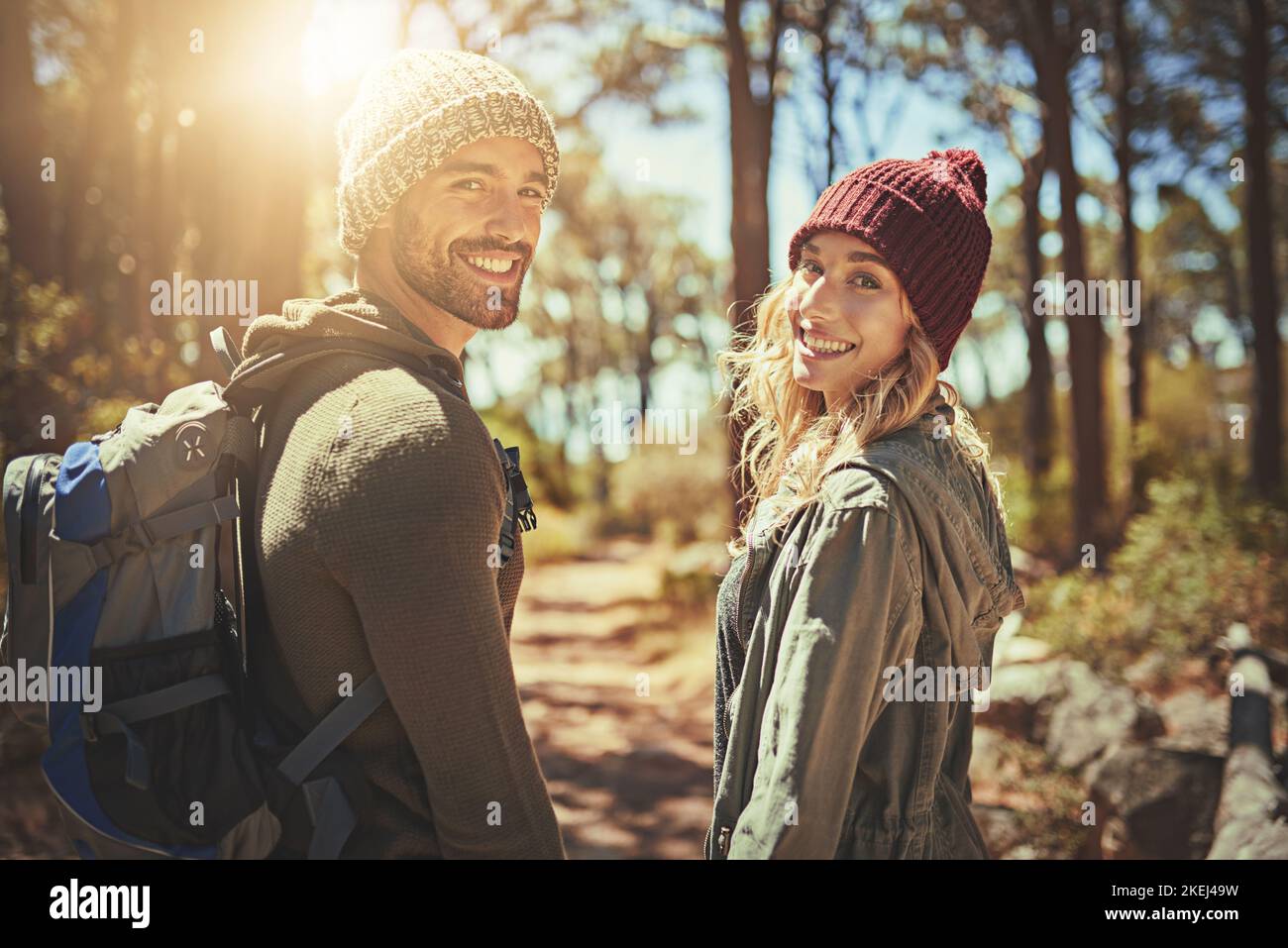 Ever wonder why we wander. Rearview shot of an affectionate young couple hiking. Stock Photo
