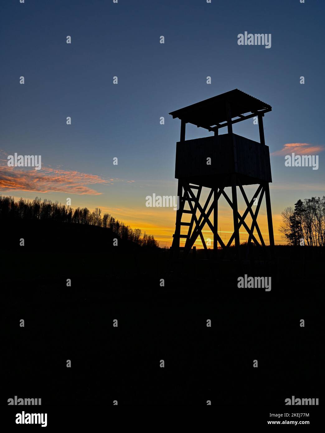 Hunting tower silhouette on sunset in blue and orange Stock Photo