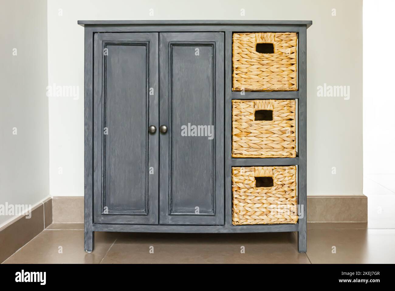 Gray wooden and wicker chest of drawer Stock Photo Alamy