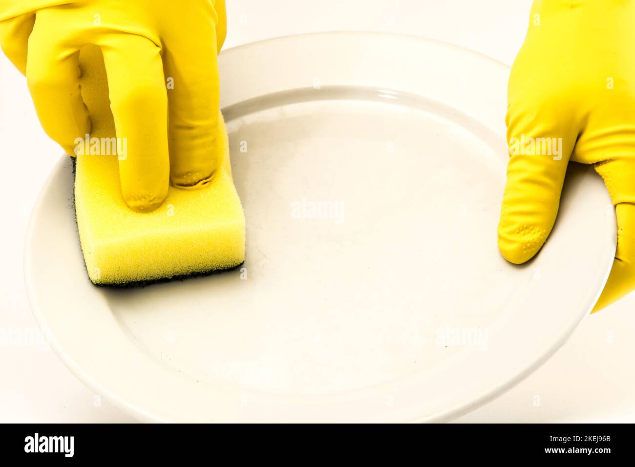 Dish washing. Yellow rubber gloves on hand Stock Photo Alamy