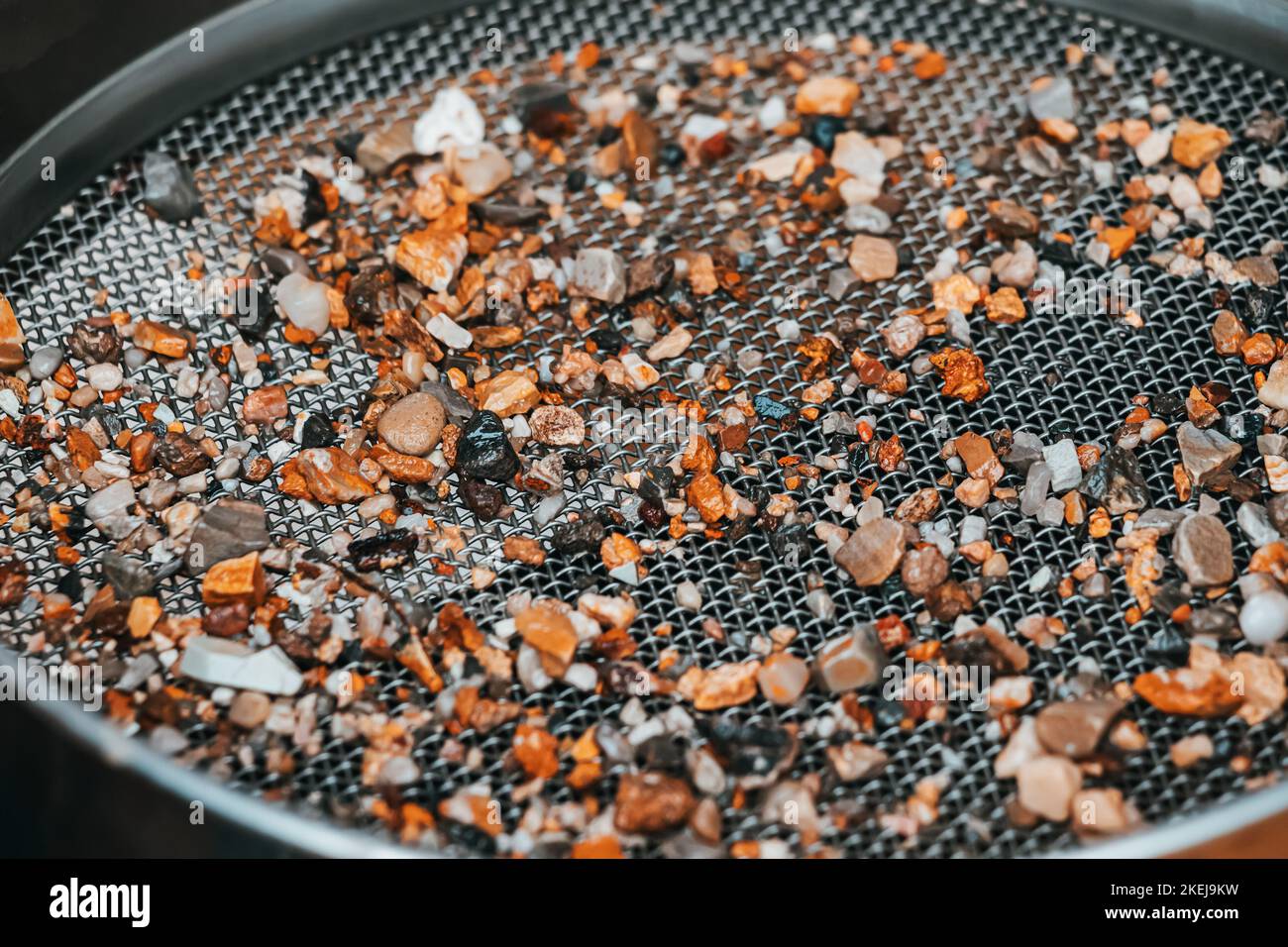 Sorting and picking of stones and pebbles in sieve at archaeological