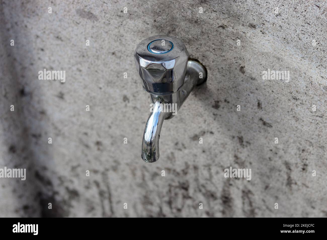 Faucet mounted on a stone wall. Top view of the faucet. Stock Photo