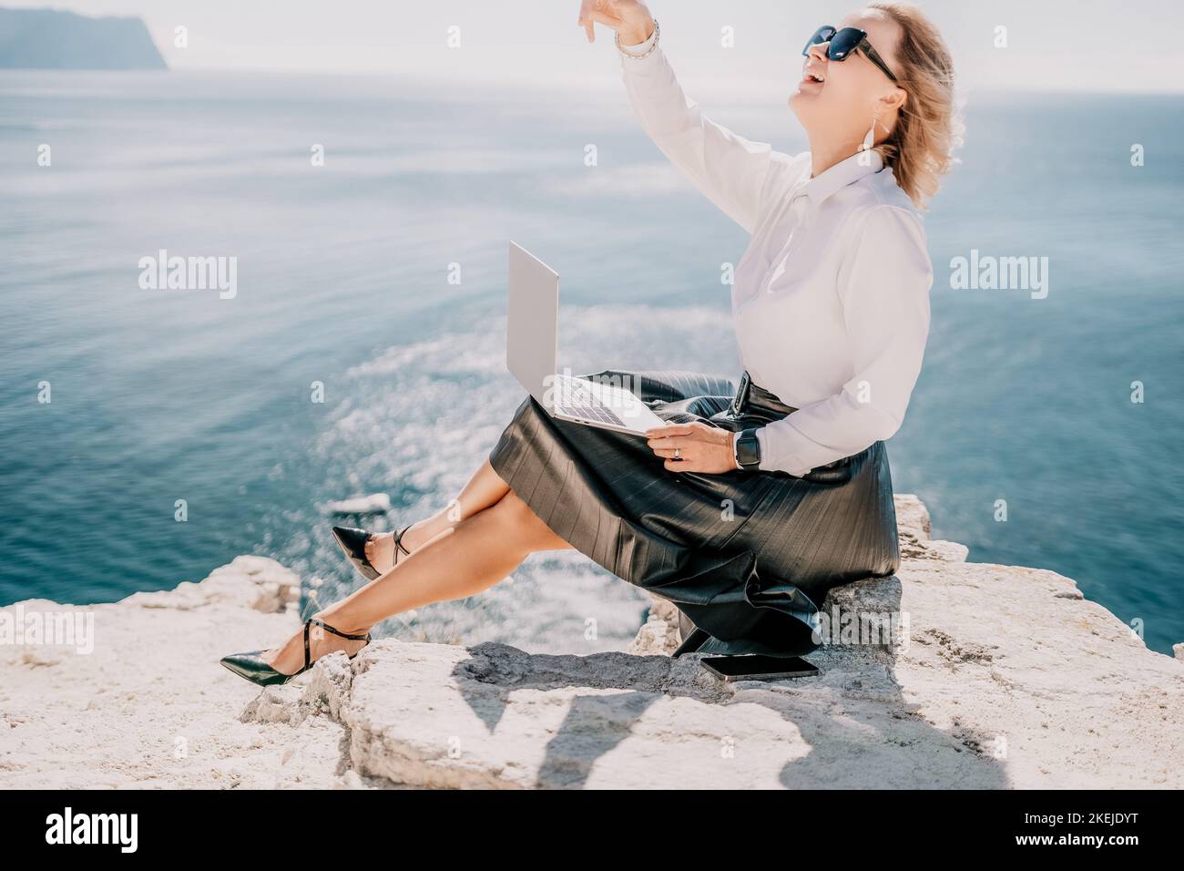 Digital nomad, Business woman working on laptop by the sea. Pret Stock Photo