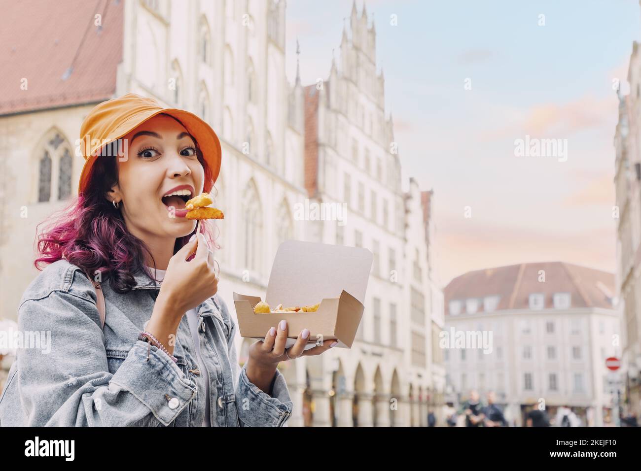 Cheerful happy girl snacking on fast food with shrimp in batter on the