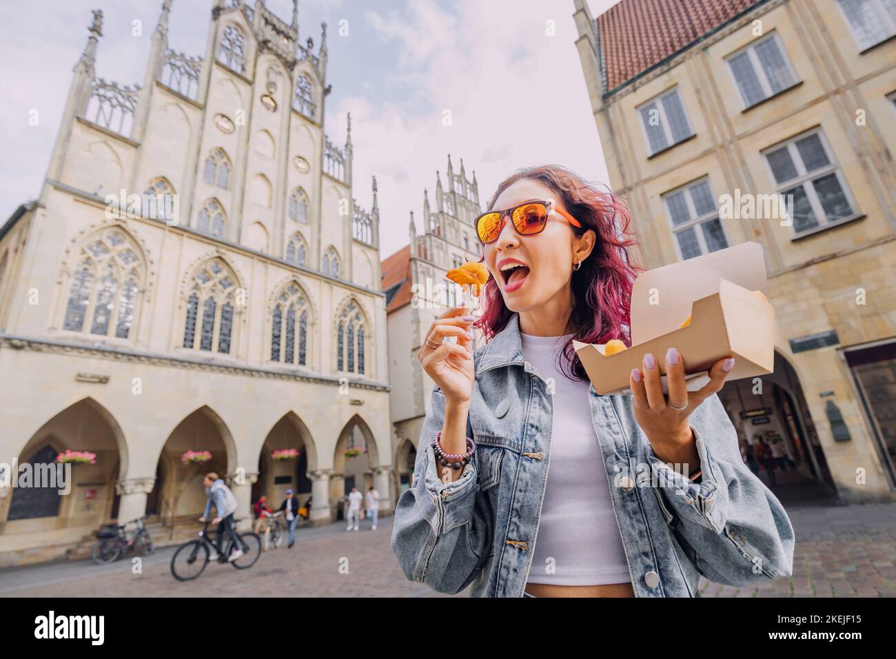 Cheerful happy girl snacking on fast food with shrimp in batter on the