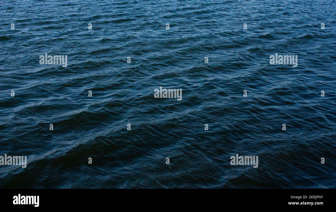 An aerial shot of abstract dark blue wavy sea water surface background ...