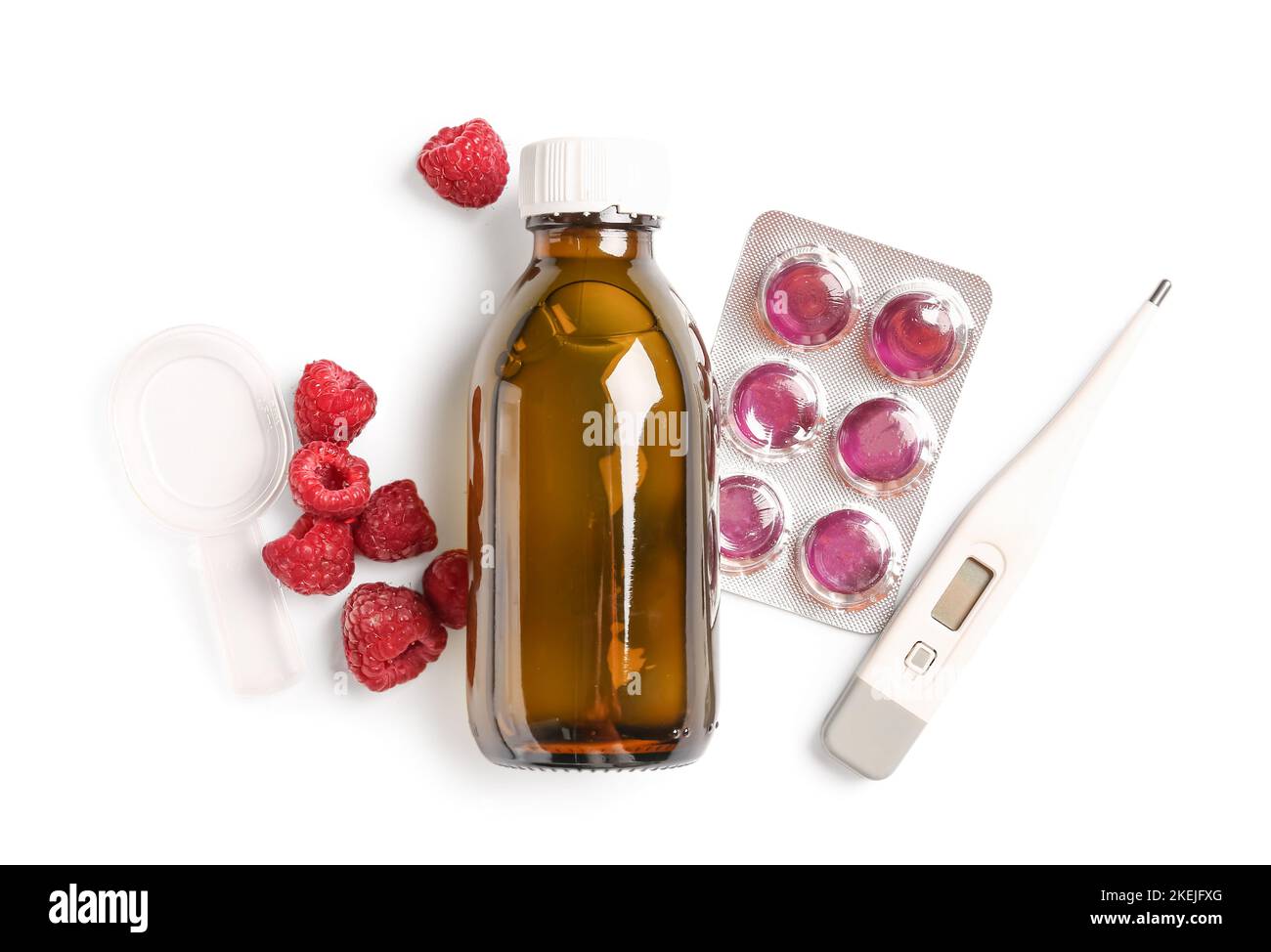 Pills for sore throat, cough syrup, raspberries and thermometer on