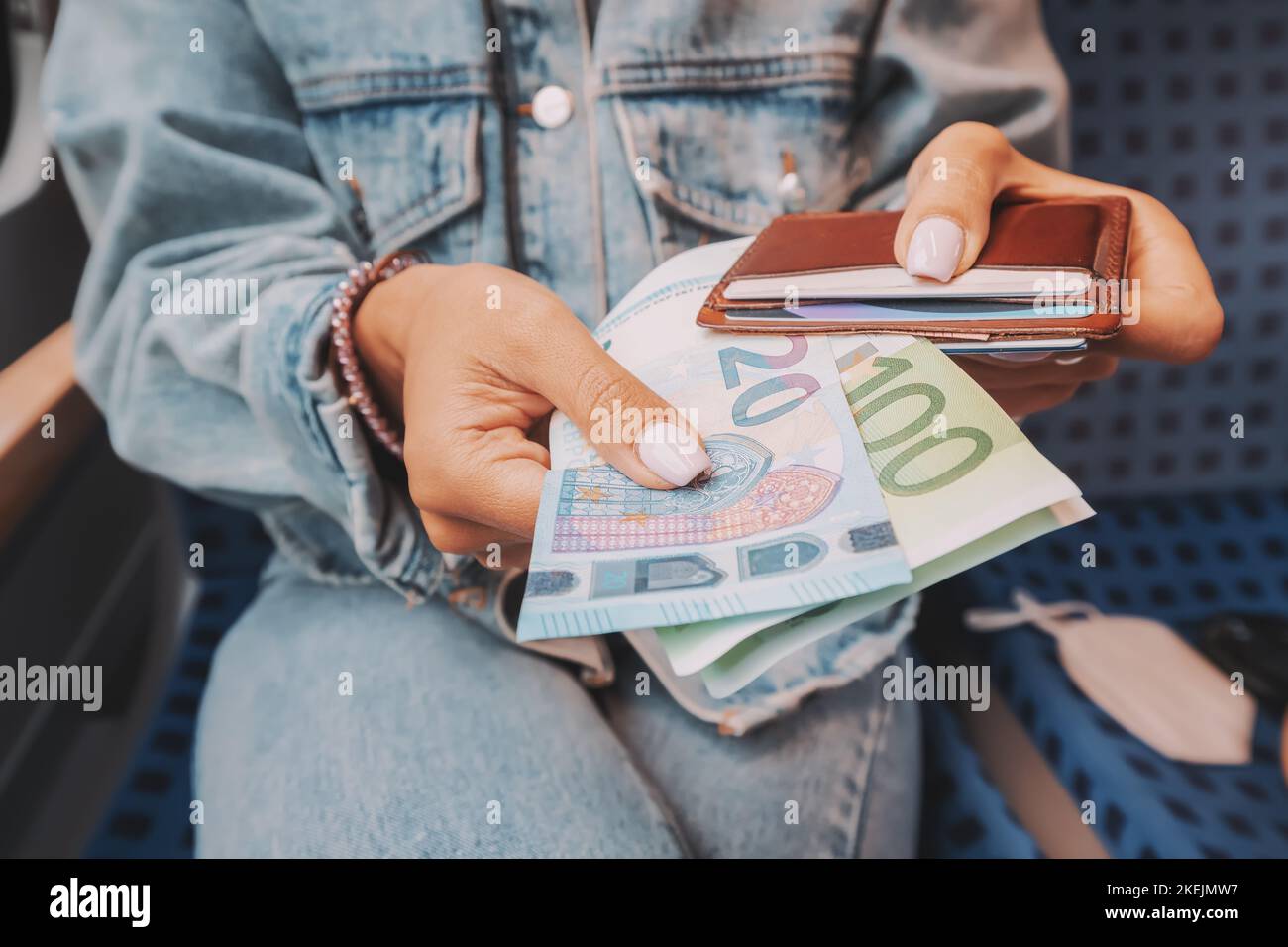 The girl takes euro banknotes out of her wallet. The concept of devaluation and inflation of the European currency Stock Photo