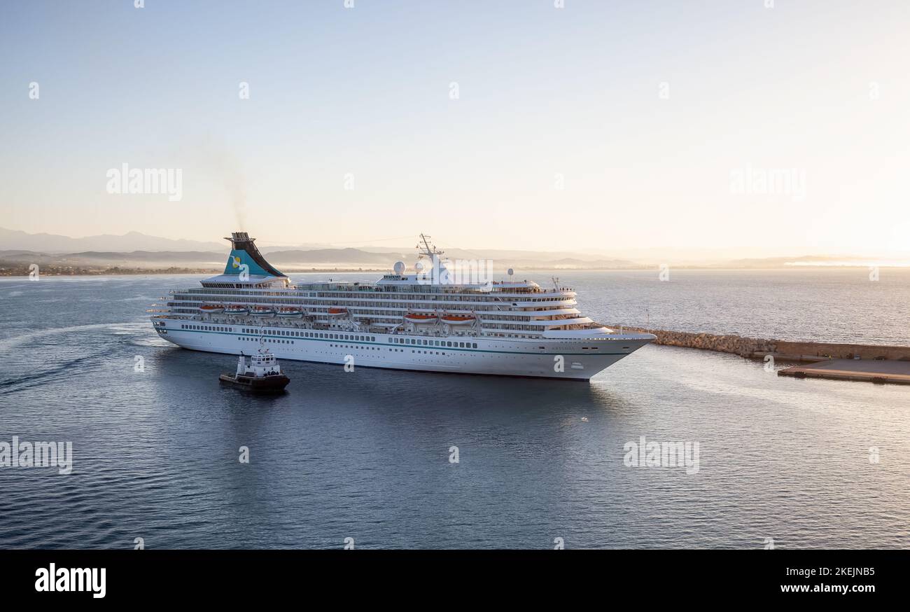 Artania Cruise Ship Arriving to a touristic town Port during sunny sunrise. Stock Photo