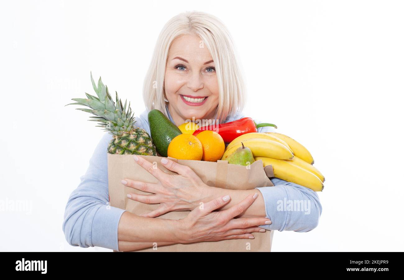 Happy beautiful woman with blond hair holds many fruits oranges, lemon,  bananas, kiwi, avocado, pears and pineapple in her hands for a healthy diet  Stock Photo - Alamy