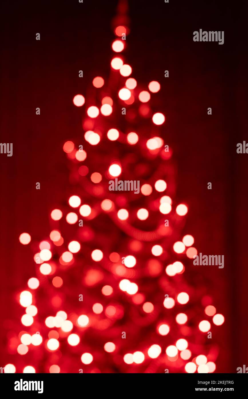 Christmas tree in lights on red background- soft focus and bokeh Stock Photo