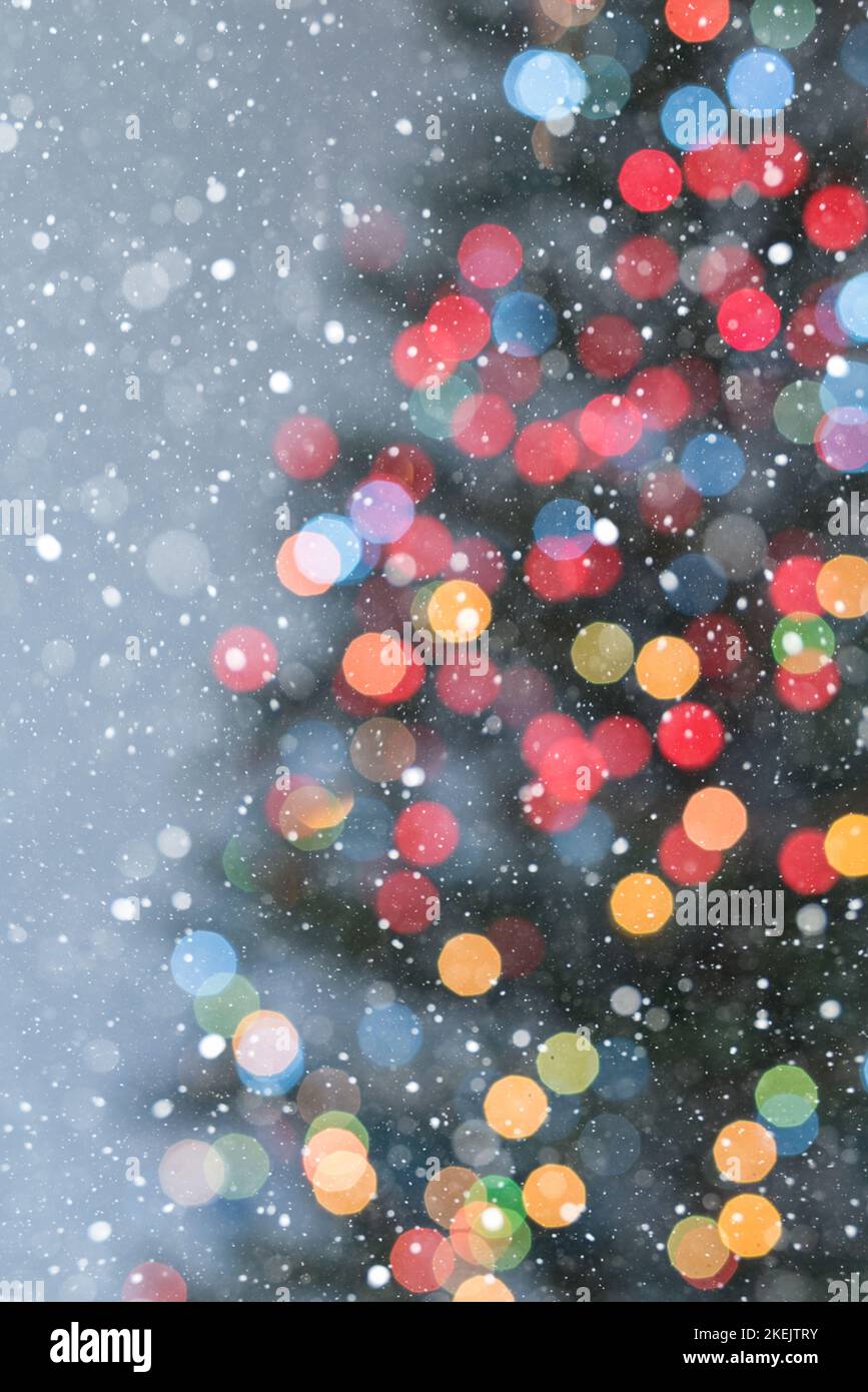 Part of Christmas tree in multicoloured lights and lots of snowflakes - soft focus Stock Photo