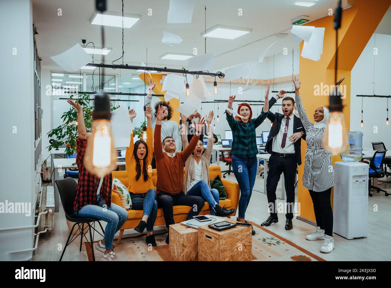 Group of business people throwing paper in air at modern startup office ...