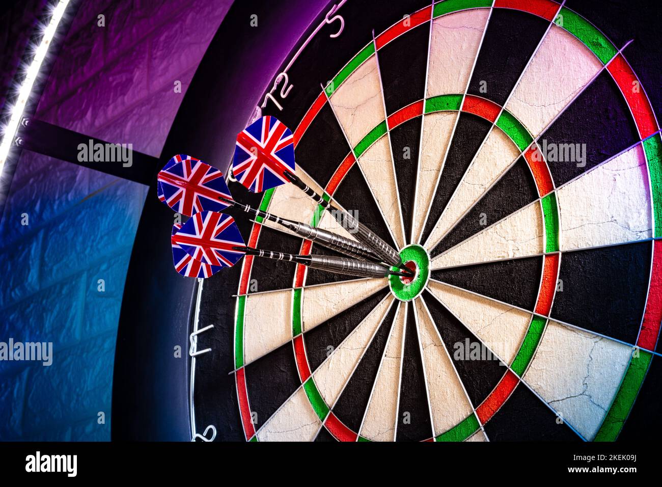 Three darts with uk flag flights in triple double bullseye on