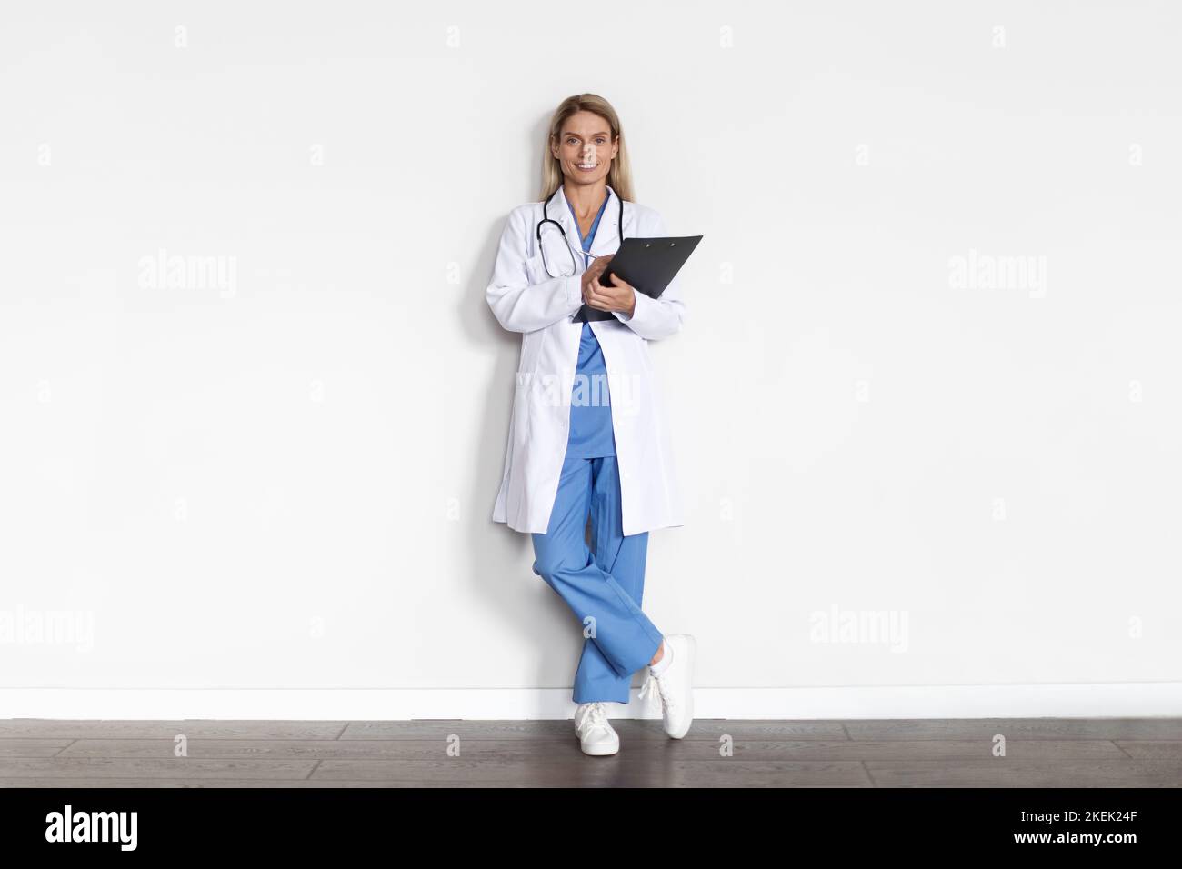 Full Length Shot Of Female Doctor In Uniform With Clipboard In Hands Stock Photo