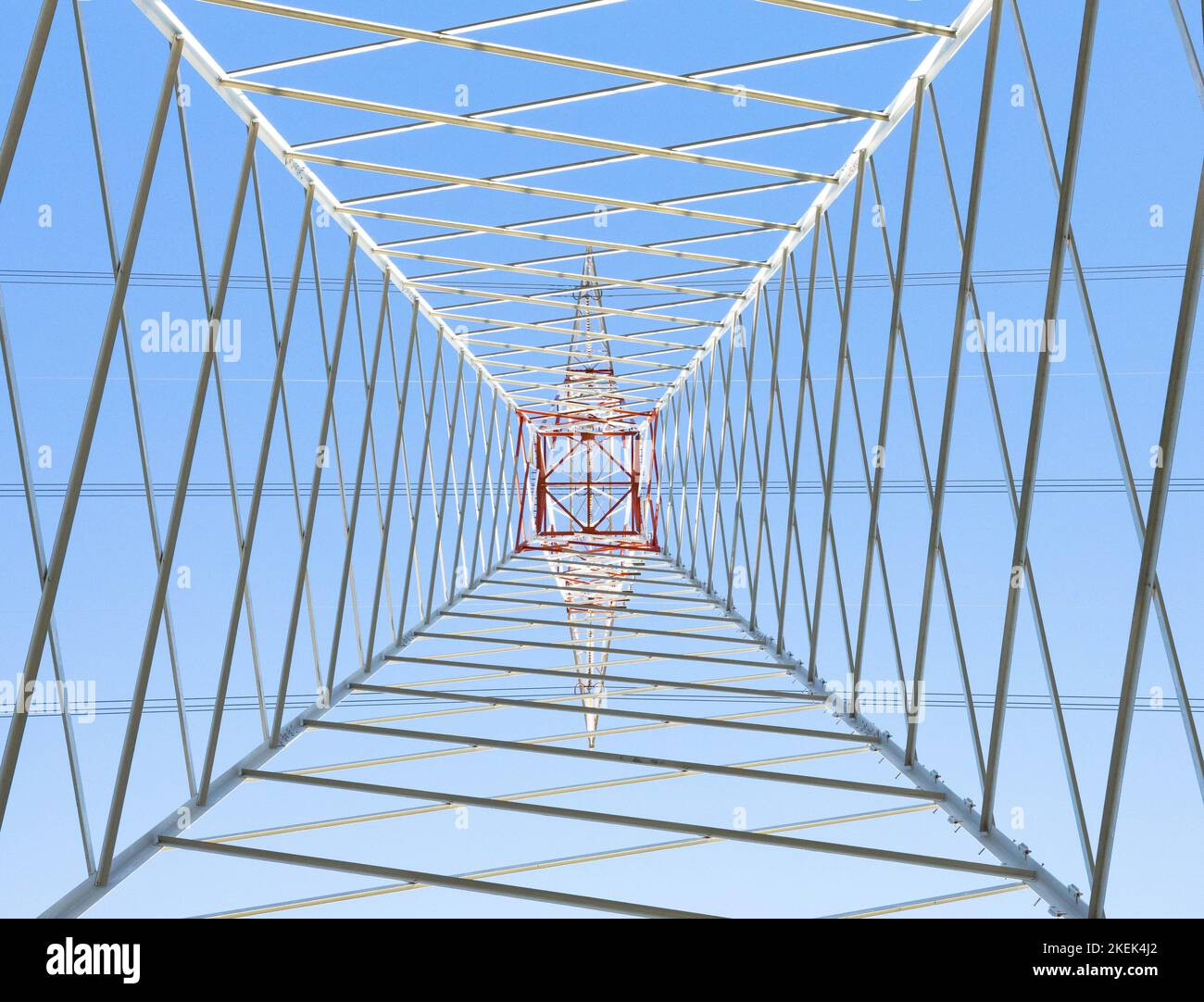 Electric pylon in perspective seen below with light blue background Stock Photo