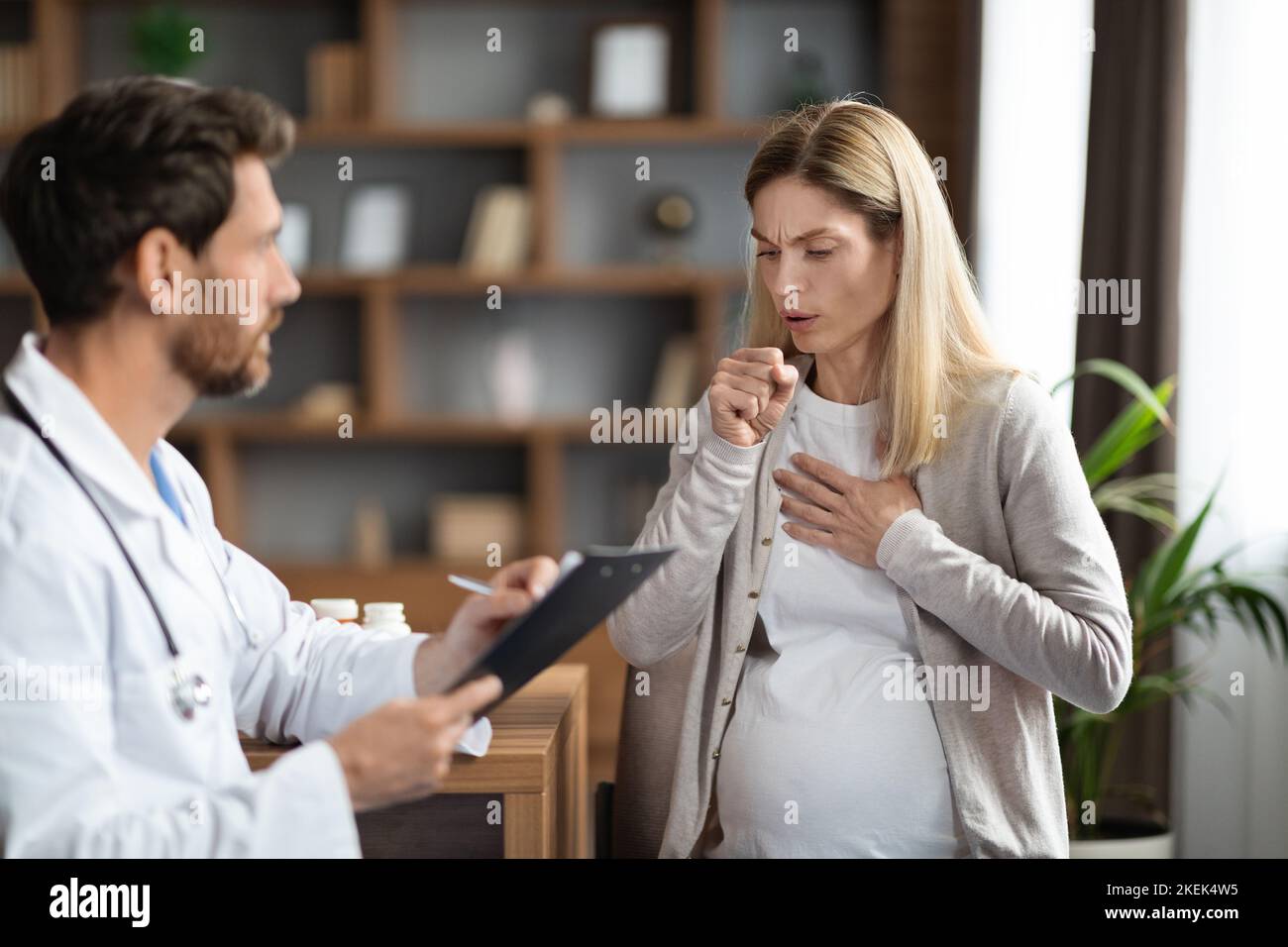 Sick Pregnant Woman Coughing During Meeting With Doctor In Clinic Stock Photo Alamy