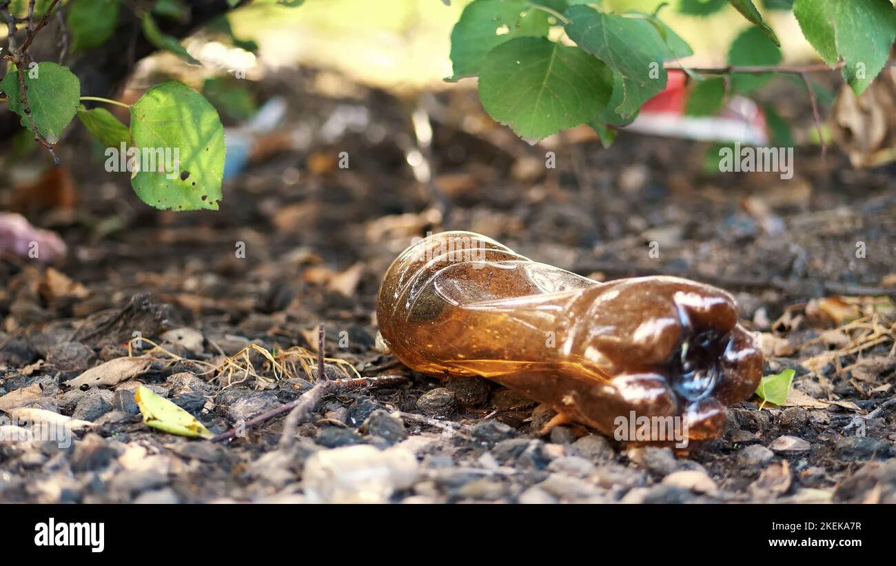 close-up, on the ground lying old used plastic bottle. garbage, trash, rubbish on street, outdoors. ecology, pollution of the environment. High quality photo Stock Photo