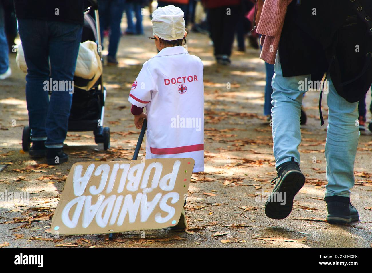 little kid in doctor disguise with the placard with text 'public healthcare' on Madrid, Spain demonstration on 13th November 2022 Stock Photo