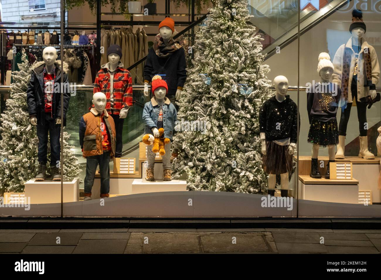 Children's winter clothing displayed in a shop window with Christmas