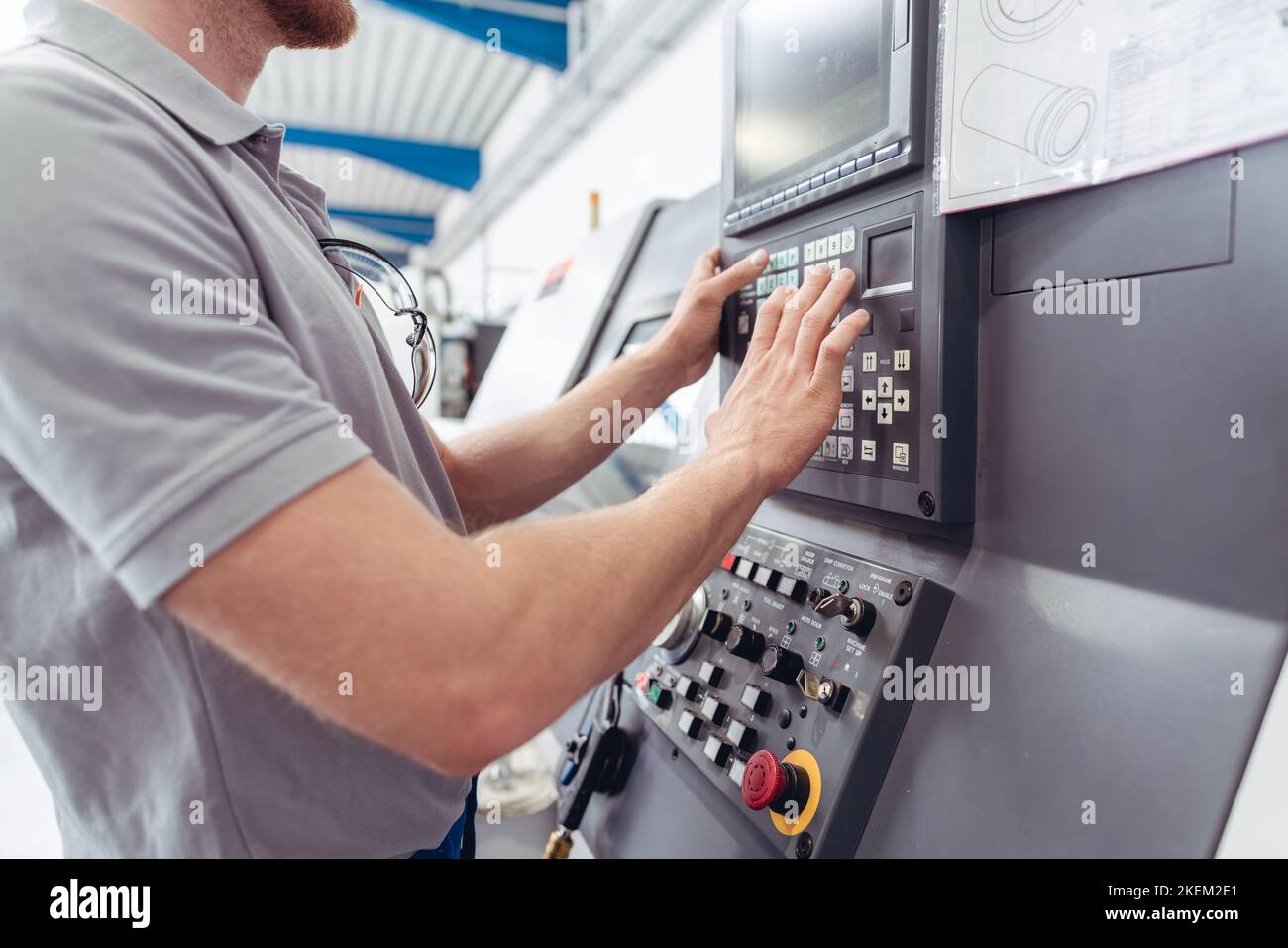Manufacturing worker programming industrial CNC machine tool Stock Photo