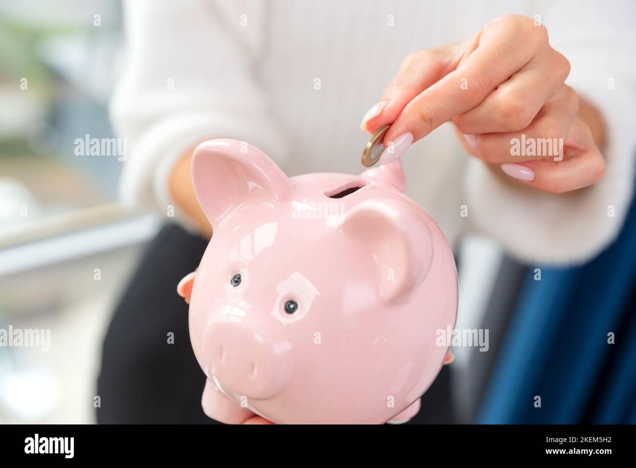 Woman putting coin piggy bank hi-res stock photography and images - Alamy