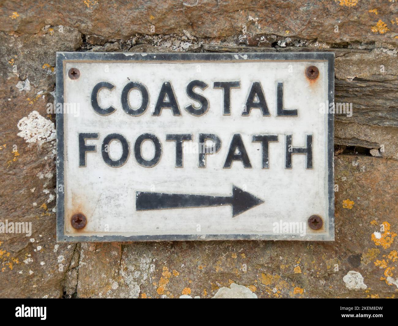 Coastal footpath sign on a stone wall in Port Quin in Cornwall, England, UK Stock Photo