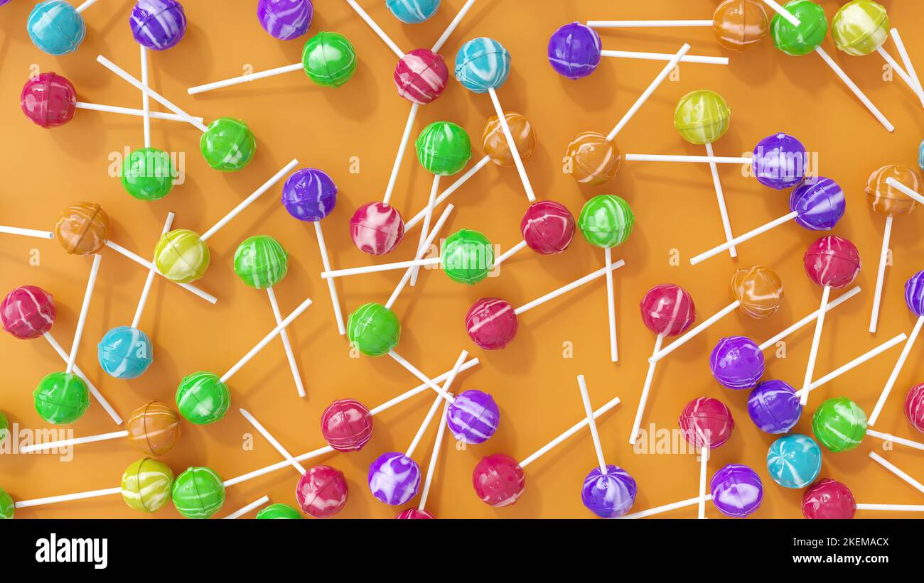 Colorful and flavored big shiny lollipops on orange pastel background