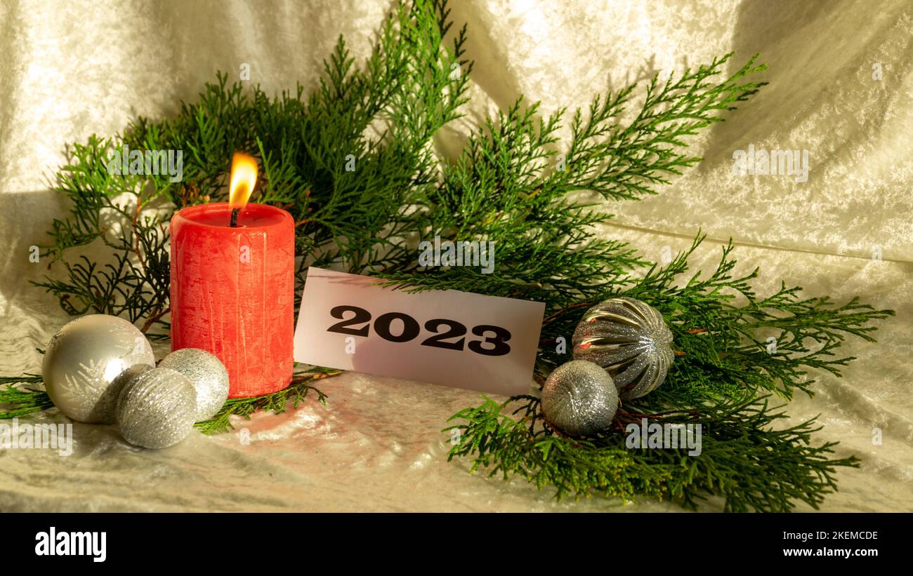 Christmas decorations on light background, red candle and text 2023 ...