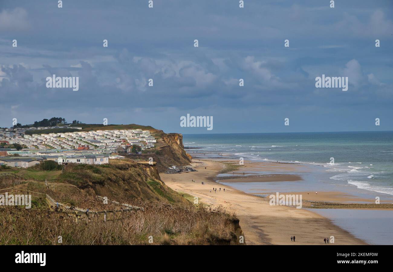 From the coast path, the beaches of the North Norfolk coastline near Cromer. A large caravan holiday park appears on the left. Taken on a sunny day at Stock Photo